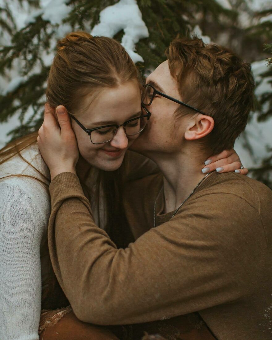 Young couple sharing a tender kiss outdoors in winter, illustrating different types of kisses and their cultural significance.