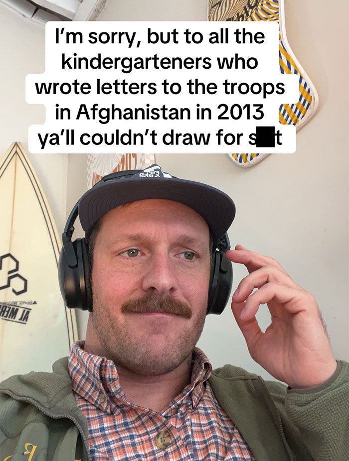 Man wearing headphones with a cap reading a sarcastic letter from kids to U.S. soldiers in Afghanistan in 2013.