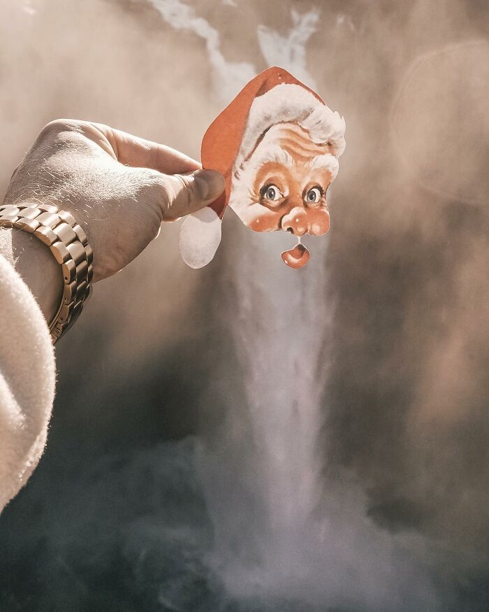 Hand holding a paper cutout of Santa’s face interacting with steam creating a whimsical real-life effect.