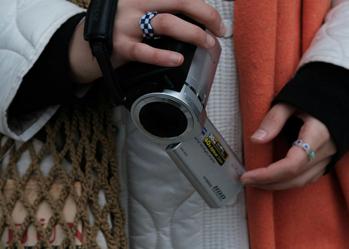 Person holding a video camera capturing footage, illustrating terrifying things found online shared by people.