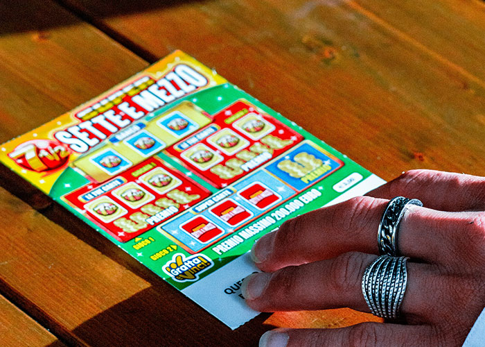 Hand holding a lottery ticket found in the walls of a home, showcasing fascinating hidden items discovered.