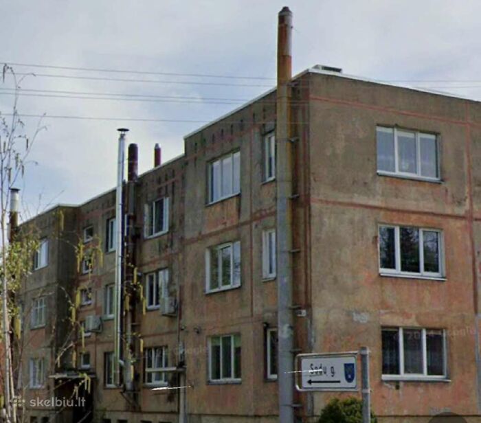 Old and worn apartment building featured in wild real estate listings with unusual property conditions.