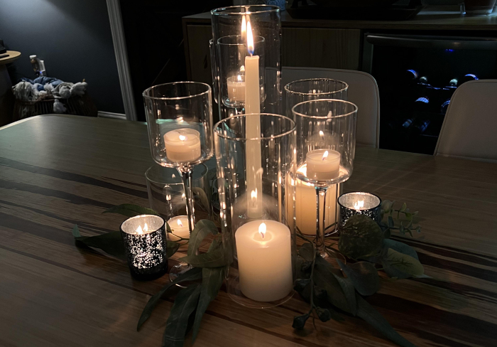 Candlelit table setting with multiple glowing candles creating a spooky atmosphere for scary games to play with friends.