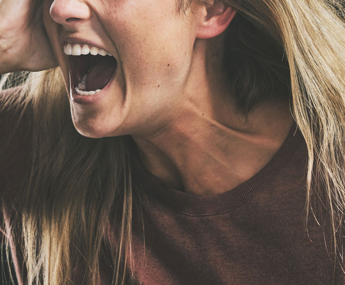 Close-up of a woman laughing loudly, capturing the funny patients’ comments that lighten hospital and clinic vibes.