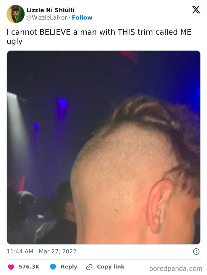 Twitter post by a woman roasting a man online with a close-up photo of a unique haircut at a dimly lit event.