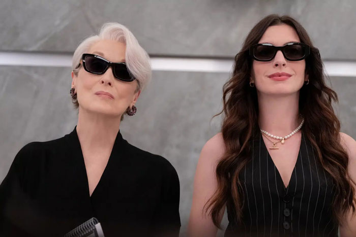 Two stylish women wearing sunglasses, representing modern movies with millennial gray tones and a sleek aesthetic.