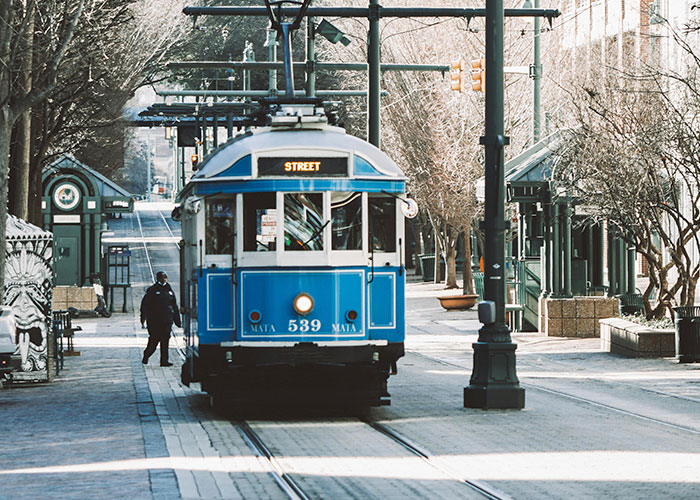 Blue streetcar numbered 539 on urban tracks with a pedestrian nearby in one of the worst cities worldwide to avoid visiting.