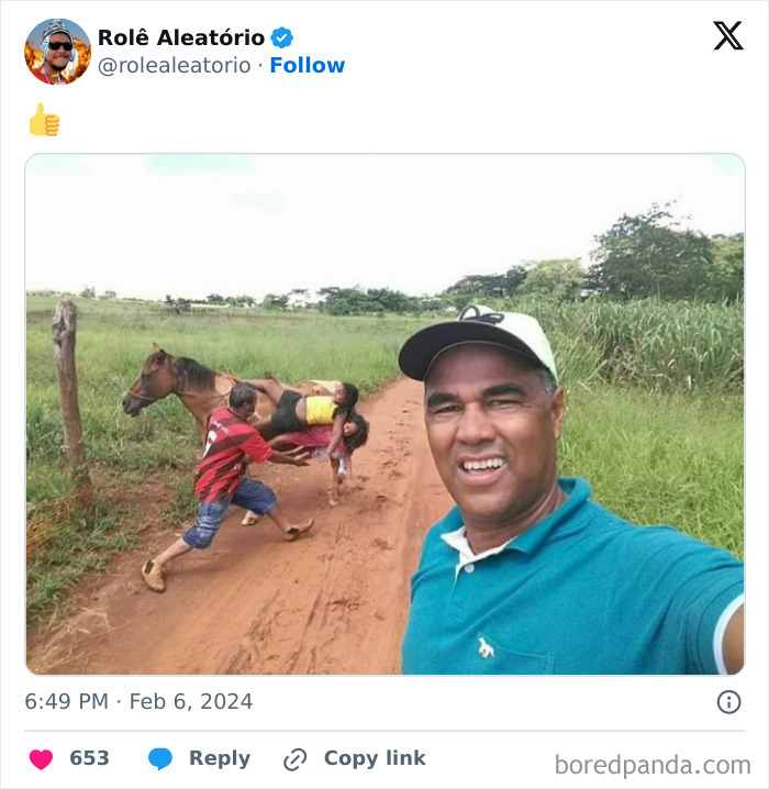 Man taking selfie on rural road with epic photobomb of people falling off a horse in background.