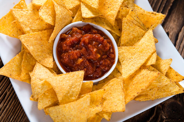 Plate of tortilla chips surrounding a bowl of salsa, symbolizing insider experiences shared by nepo babies.