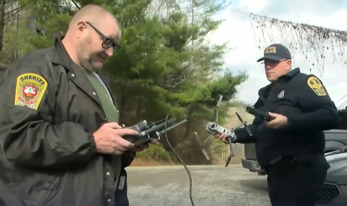 Two law enforcement officers operating a drone during investigation of missing football coach case outdoors. Two law enforcement officers operating a drone during investigation of missing football coach case outdoors.