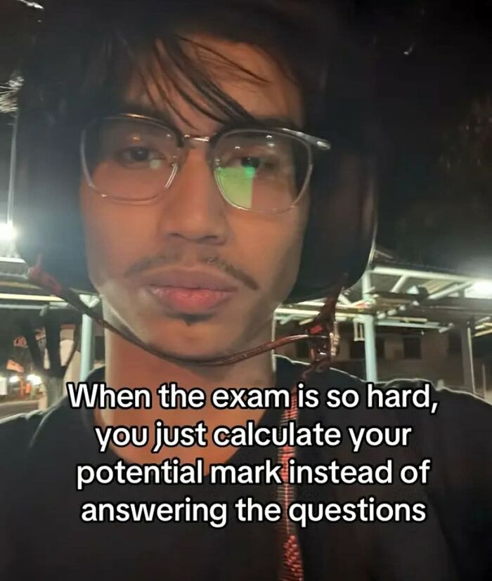 Young man wearing glasses and a helmet making a funny face with hilarious educational memes about hard exams text overlay.