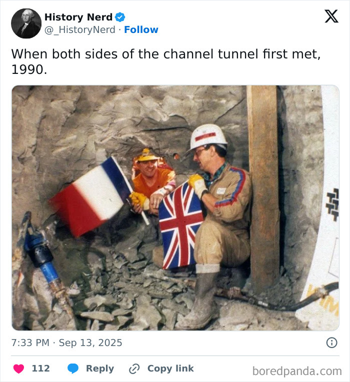 Two workers with French and British flags inside the Channel Tunnel, a rare and powerful photo from history.