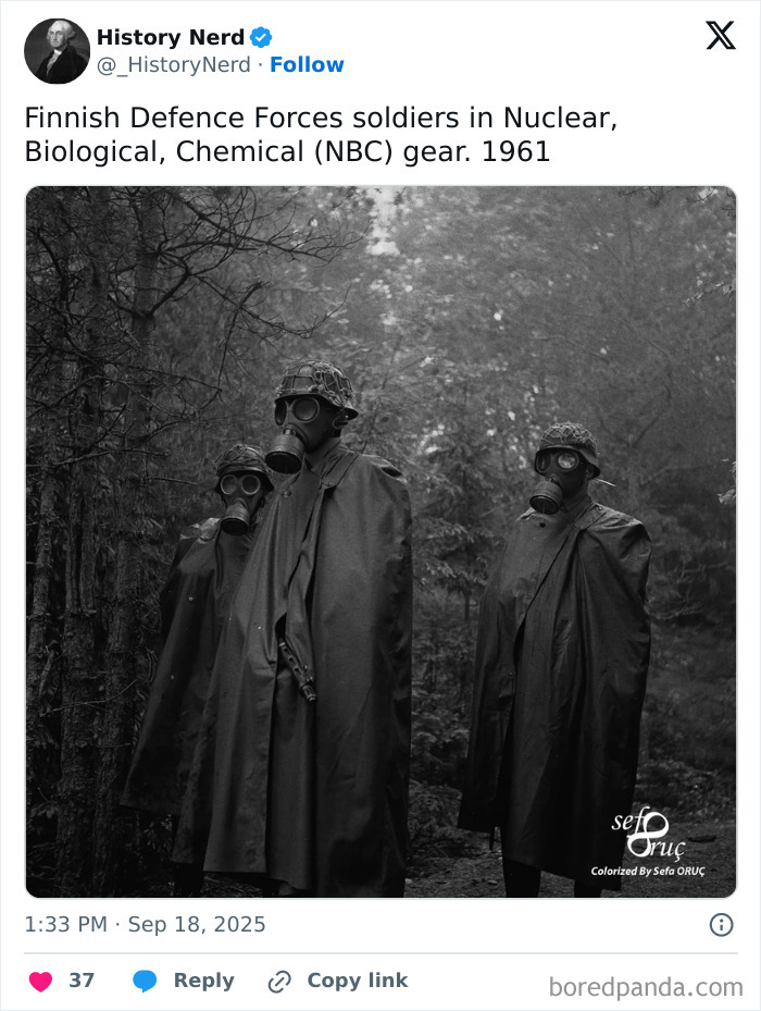 Finnish Defence Forces soldiers in 1961 wearing nuclear, biological, chemical gear standing in a forest scene from history.