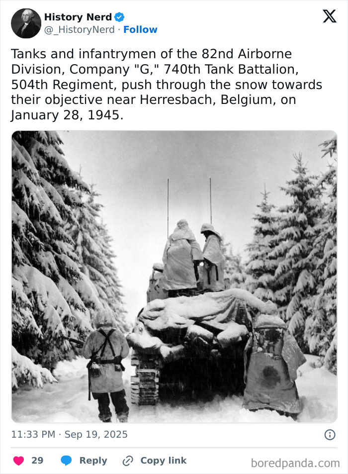 Tanks and infantrymen of the 82nd Airborne Division push through snowy forest during WWII in a powerful history photo.