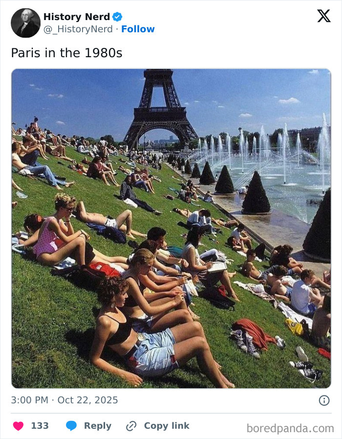 People relaxing on grass near fountains with Eiffel Tower in the background, a rare and powerful history photo from the past.