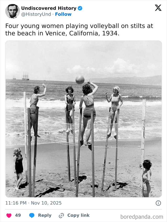 Four young women playing volleyball on stilts at a California beach, a fascinating photo revealing moments lost to time.
