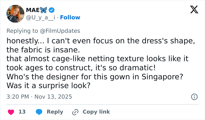 Michelle Yeoh in dramatic wasp nest inspired outfit at premiere, featuring cage-like netting texture and intricate fabric design.