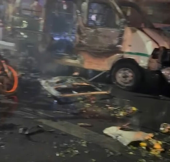 Burnt-out vehicle and debris on street after horror car blast shakes capital city in terror attack leaving casualties.