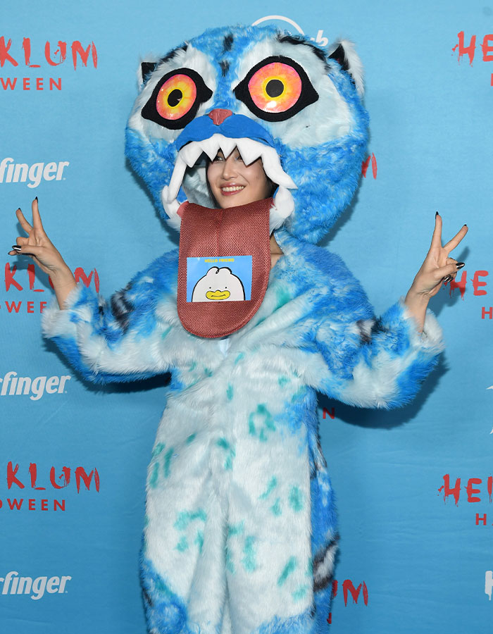 Disfraz de celebridad sorprendente con traje azul y lengua larga en el evento de Halloween de Heidi Klum 2025.