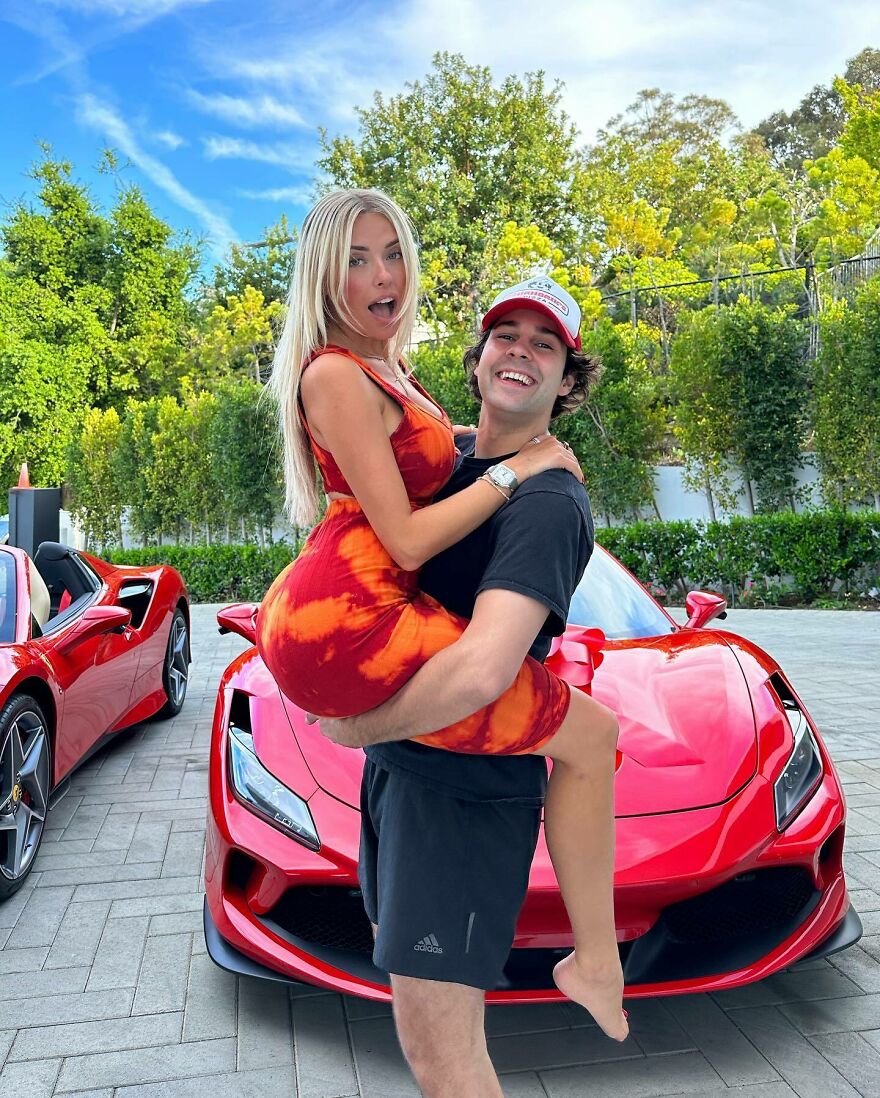 Corinna Kopf posing with a man in front of red sports cars, highlighting internet fame and impressive net worth. Corinna Kopf posing with a man in front of red sports cars, highlighting internet fame and impressive net worth.