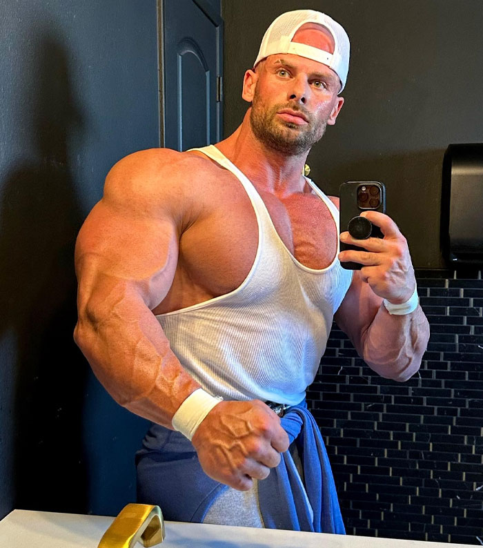 Joey Swoll flexing muscles in a gym bathroom while taking a selfie, related to Gold's Gym trans locker controversy. Joey Swoll flexing muscles in a gym bathroom while taking a selfie, related to Gold's Gym trans locker controversy.