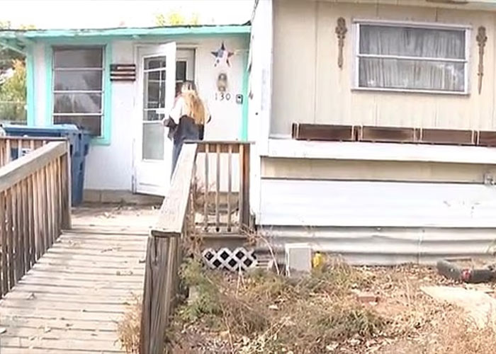 Woman entering a weathered house with a wooden ramp, scene related to missing woman&rsquo;s body discovered in garage case.