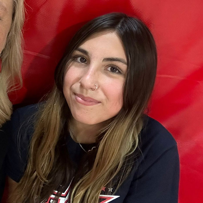 Teen girl with long brown hair and nose ring sitting against a red background relating to step-uncle arrested case. Teen girl with long brown hair and nose ring sitting against a red background relating to step-uncle arrested case.