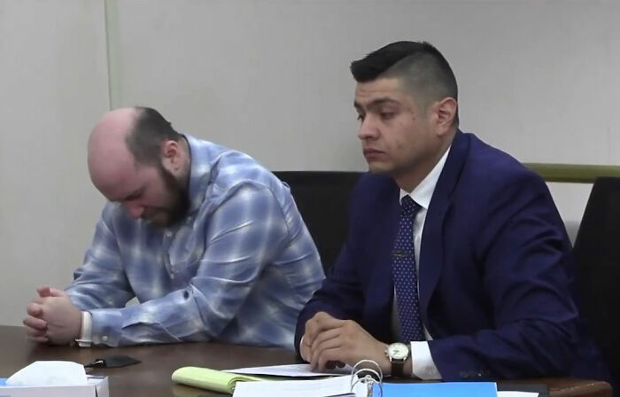 Man in plaid shirt and lawyer in suit at table during legal proceeding about man leaving daughter in burning car. Man in plaid shirt and lawyer in suit at table during legal proceeding about man leaving daughter in burning car.