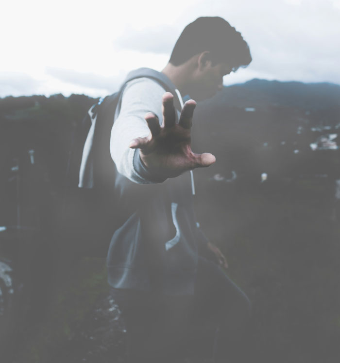 Person reaching out hand toward camera in an outdoor setting, symbolizing an Oscar-worthy performance moment.