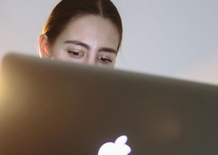 Woman looking at laptop screen with a concerned expression, experiencing terrifying things found online.