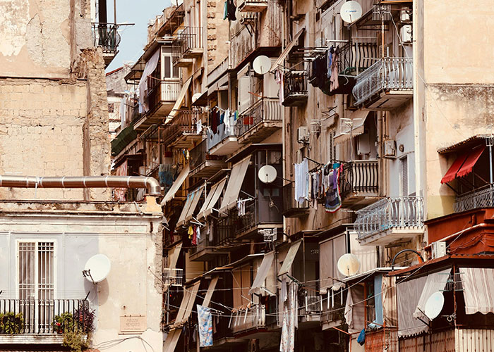Old rundown apartment buildings with balconies and hanging laundry in one of the worst cities worldwide to avoid visiting.