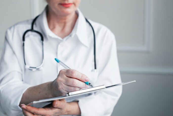 Doctor in a white coat holding a pen and clipboard, representing subtle signs that scream they’re cheating concept.