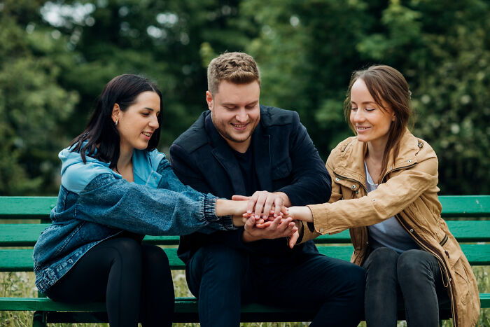 Three young adults sitting on a bench showing support and connection, illustrating signs child never loved properly.
