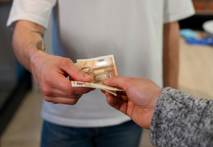 Two people exchanging cash, illustrating stories from people who messed up once and learned their lesson.