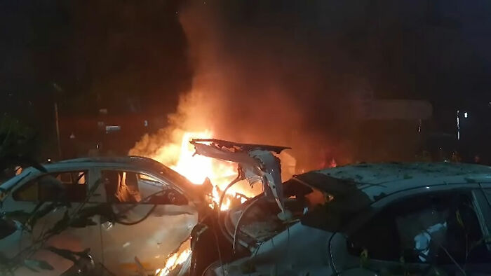 Burning cars engulfed in flames at night after a horror car blast shakes the capital city with severe destruction.