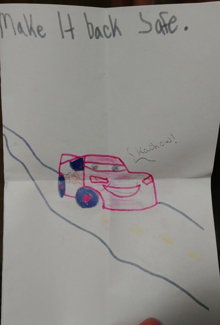 Child&rsquo;s drawing of a smiling red car on a road with a message for U.S. soldiers to make it back safe
