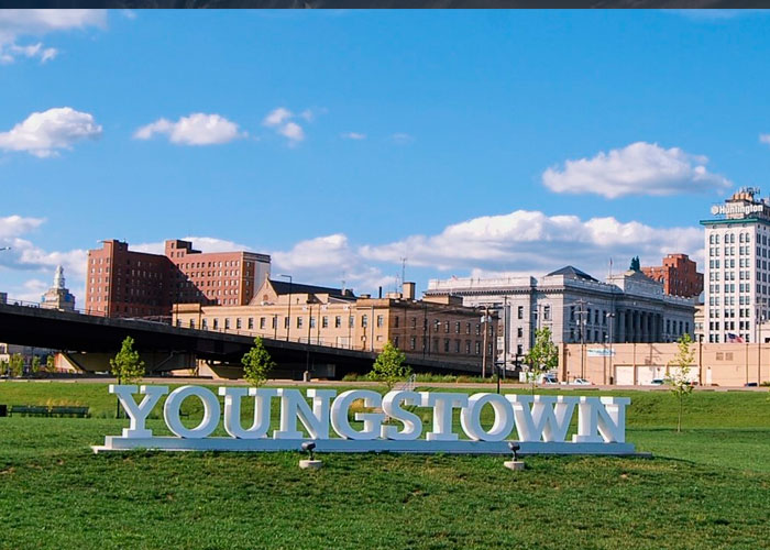Youngstown cityscape with large white sign in foreground, representing one of the worst cities worldwide to avoid visiting.