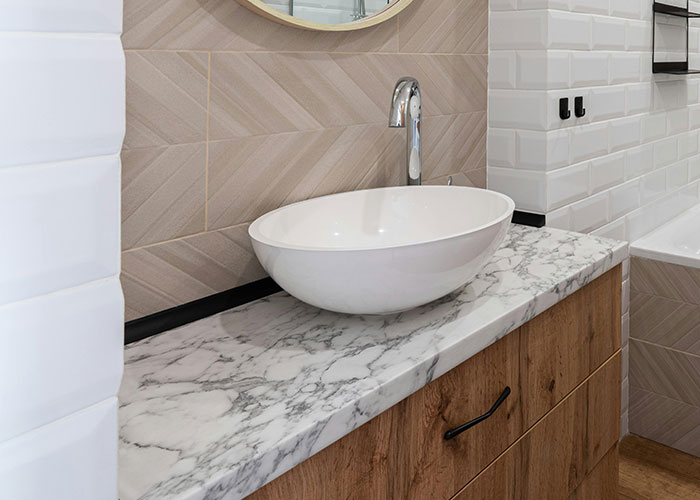 Modern bathroom sink with marble countertop and wood cabinetry showcasing genius cleaning hacks inspired by laziness.