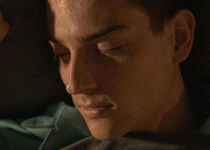 Close-up of a young man with eyes closed, appearing unsettled, reflecting bizarre events that creep people out.