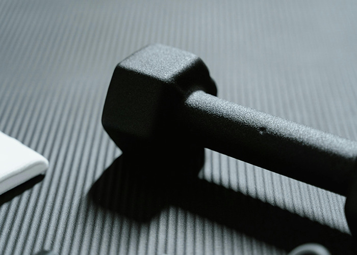 Black dumbbell lying on a textured mat representing one of the absolute horrible gifts people have actually received.