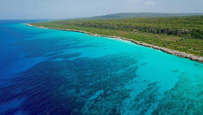 Coastal view of a foreign island with clear blue waters, linked to arrests over plans to sail and commit crimes.