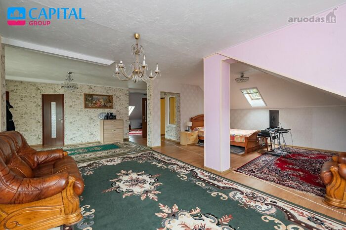 Amplia sala con alfombras y muebles de cuero en listado entretenido de bienes raíces encontrado en página de Facebook.