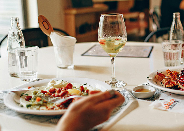 Casual dining table with plates of food, glasses, and utensils, illustrating lazy genius cleaning hacks in everyday life.