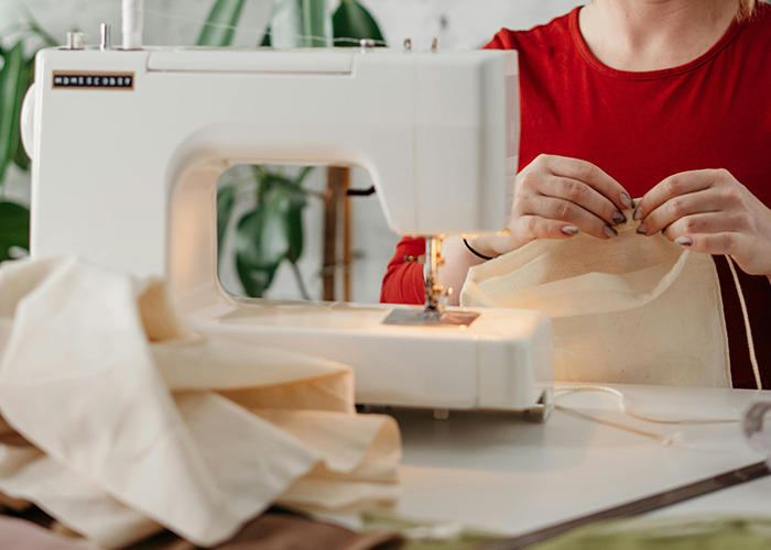 Person using a sewing machine to work with fabric, illustrating one of the absolute horrible gifts described by 91 people.