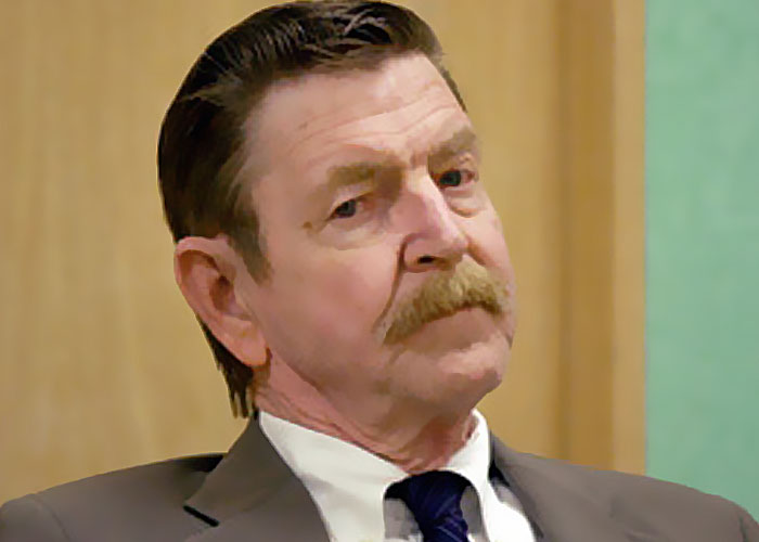Middle-aged man with mustache wearing suit and tie, looking serious, representing terrifying things found online.