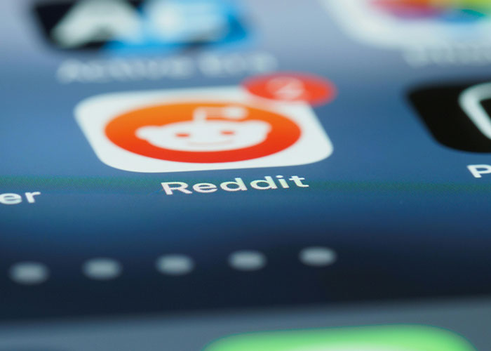 Reddit app icon on a smartphone screen, symbolizing a platform sharing true stories of bizarre events that creep people out.
