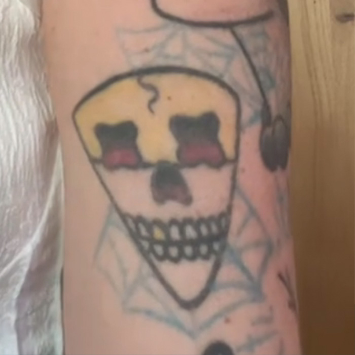 Tattoo artist's skull tattoo with spider web, illustrating viral tattoo regrets and challenges faced after Miley design.