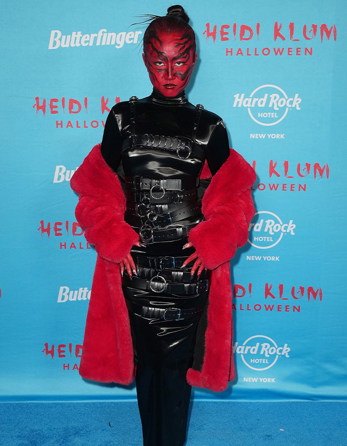 Disfraz de celebridad impactante en Halloween, con maquillaje rojo y vestido negro de cuero, en evento de Heidi Klum 2025.