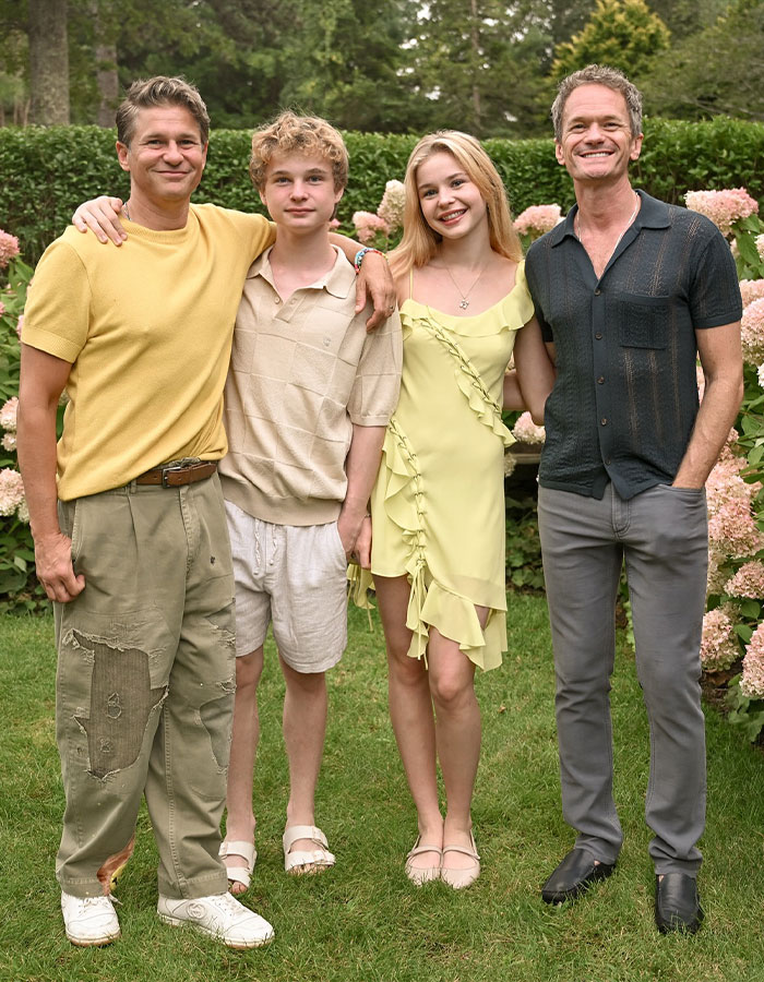 Neil Patrick Harris and family posing outdoors in casual clothing, capturing a joyful moment together.