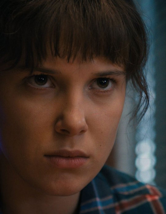 Close-up of Millie Bobby Brown with a serious expression, related to bullying allegations on Stranger Things set.